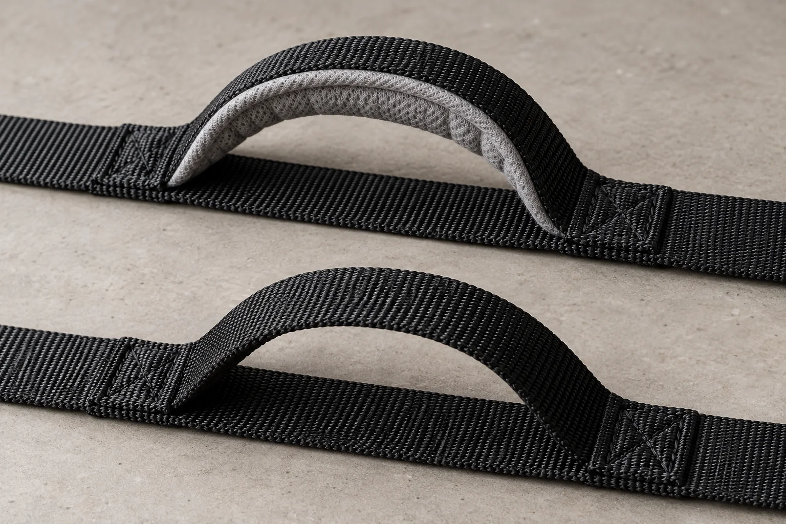Grey-lined padded and unpadded black nylon traffic handles shown together.