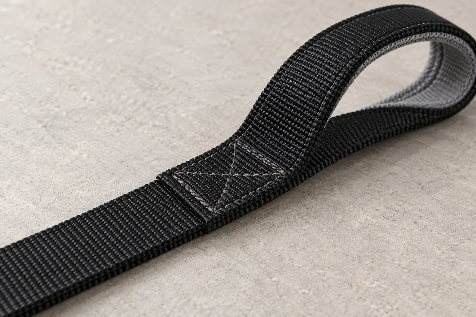 Close-up of a stitched nylon traffic-handle attachment with a grey inner lining.